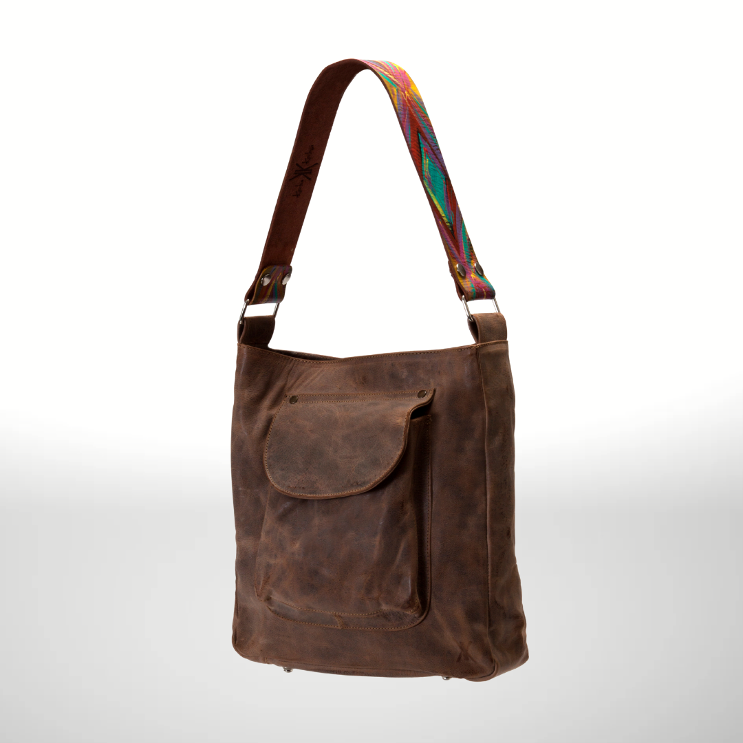 Brown leather shoulder bag with a colorful strap on a white background